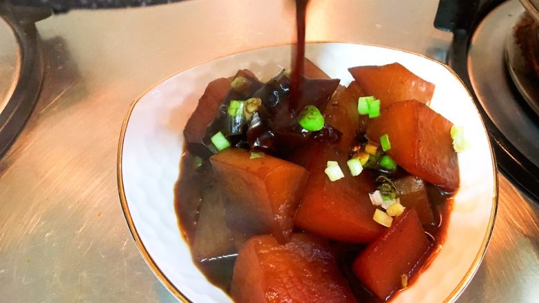 上海菜-红烧萝卜,先盛萝卜，撒上葱花，再把酱汁浇在上面