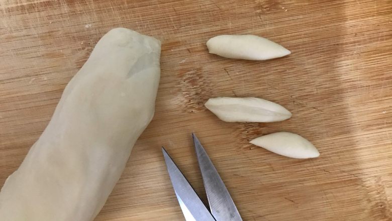芝麻酱剪刀鱼面,煮水的同时，我们来处理面团，左手拿面团，右手剪刀，一边旋转面团一边剪
