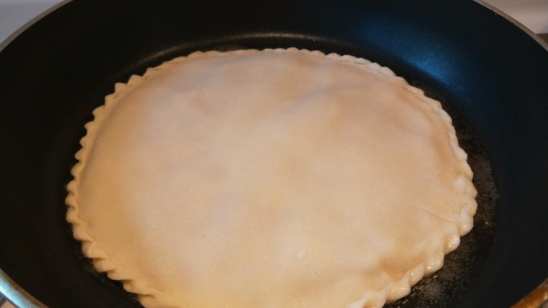 薄皮大馅牛肉豇豆饼,平底锅烧热倒入适量油，放入馅饼。