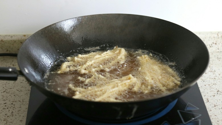 椒盐金针菇,油锅烧热，放入金针菇中火炸至金黄