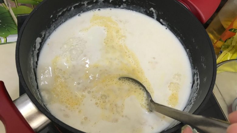 营养全面超完美早餐：牛奶鸡蛋煮麦片+蜂蜜+芒果,用勺子将鸡蛋液打散