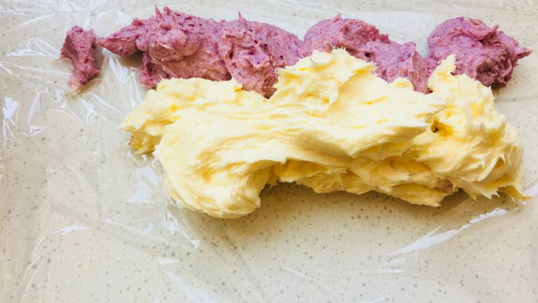 紫薯魔法棒,馅料制作非常简单，奶油奶酪软化后加入糖粉搅拌至无颗粒，加入软化的黄油以及调色的水果粉。这次做双色，加完黄油打顺后，分成两部分，只需要一部分加入紫薯粉。取一个保鲜膜，将两个颜色的奶酪平行放置于保鲜膜上。
