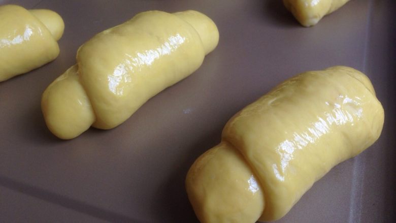 芒果面包卷,发酵好的面包胚表面涂上鸡蛋液。