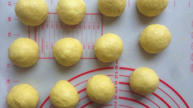 芒果面包卷,发酵好的面团轻压排气，分成12等份，滚圆，盖上保鲜膜松弛15分钟。