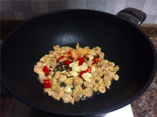 泡椒鸡肉,放入花椒、大蒜、泡椒和泡姜翻炒10秒。