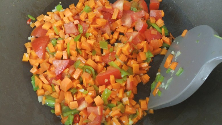 家常意面,倒入胡萝卜丁、番茄丁和火腿丁爆炒2分钟