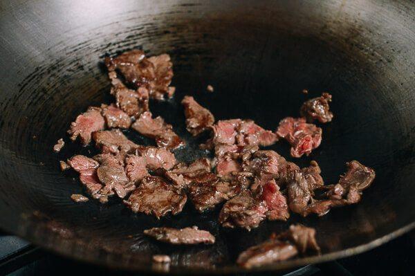 油条牛柳,锅烧热，看到冒烟在锅周围撒上一大勺油。加入牛肉翻炒2至3分钟直到变成褐色。从锅中取出，放在一边。