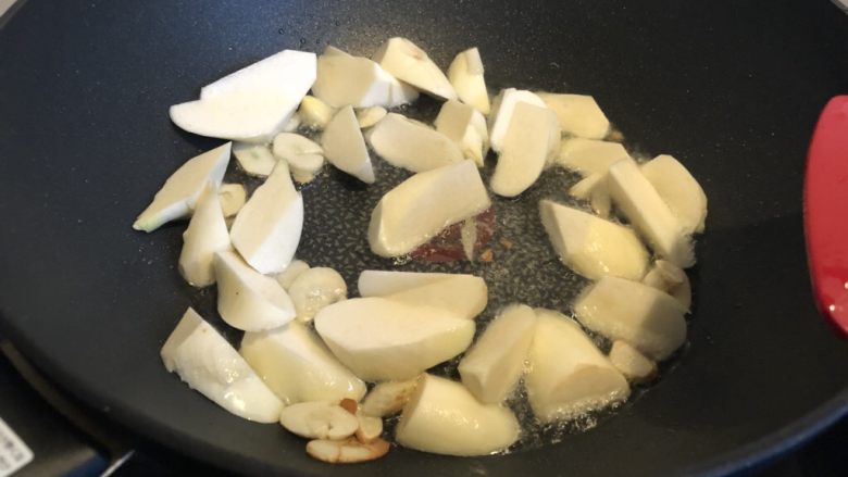 少油版油焖茭白,蒜片略煎后，下茭白翻炒。