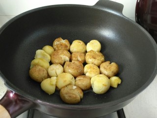 香煎小土豆,锅中放少许食用油，放入按扁的小土豆中小火煎