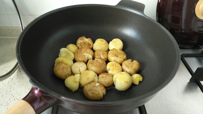 香煎小土豆,锅中放少许食用油，放入按扁的小土豆中小火煎