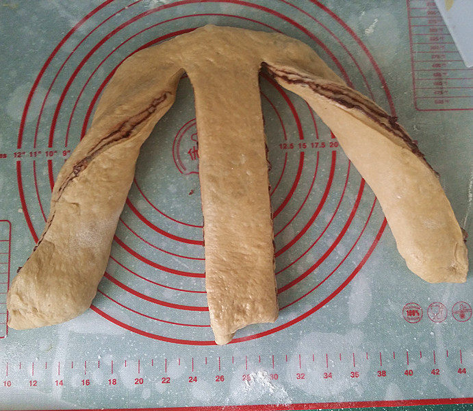 咖啡酸奶豆沙面包 #独创配方、全新做法# ,将面团转下然后用擀面杖擀开、擀大成个长方形，再用刮板竖划2刀、如图