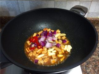 西芹泡椒爆鱿鱼,放入泡椒、泡姜、大蒜和洋葱翻炒10秒。