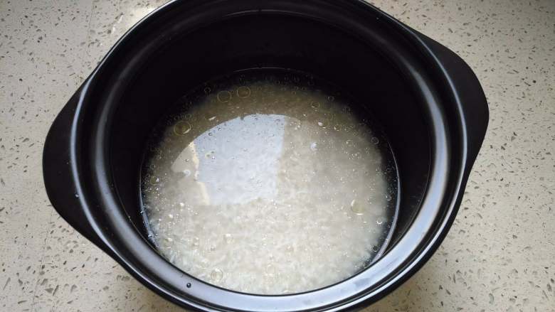 腊味煲仔饭,米淘洗干净，放入适量清水倒进砂锅，浸泡30分钟到1小时，让大米充分吸收水分。因为米的吸水量是不一样的，所以水的用量，要根据自己的大米的量和品种调节。另外淘米的水千万别扔掉啊，后面用来洗菜。
