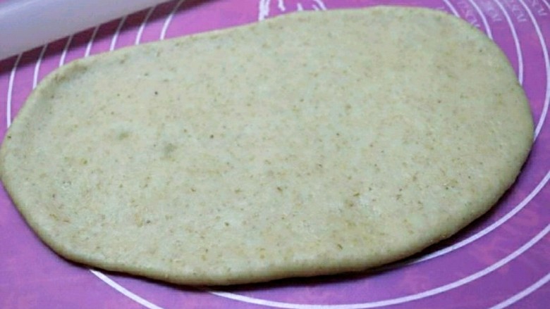 快手版全麦法棍面包,取一个面团，用擀面杖擀成长条状。