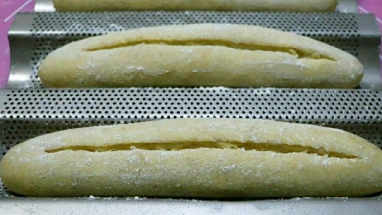 快手版全麦法棍面包,表面撒一点全麦粉，用锋利的刀在表面划一道深深的口子。