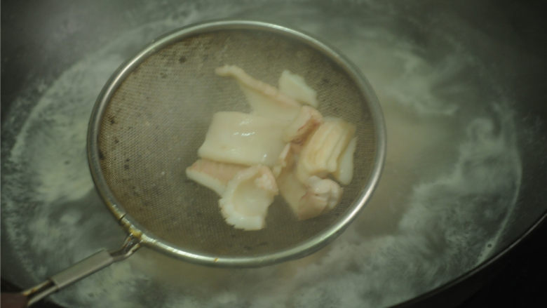 芹菜炒鱿鱼卷,锅里防水烧开，放入鱿鱼片汆烫至卷缩后立即捞出沥水