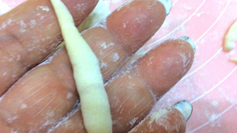 辣炒手搓土豆面鱼,取一个丁，放在手心，两手对搓，搓成两头尖，中间粗，如图