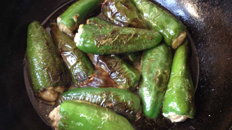 酿青椒,放入炸好的青椒盖上盖，中小火煮约8-10分钟，待汤汁收至较稠即可出锅