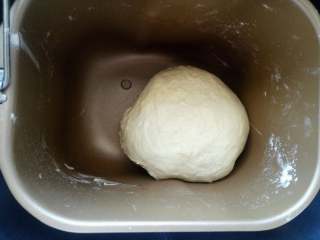 肉松面包卷【汤种法】,除黄油外的主面团材料放入面包机，揉成光滑的面团（我用了两个10分钟的程序），顺序是先放水或牛奶，再放鸡蛋，一角放盐对角放糖，加入面粉，面粉上面挖小洞埋入酵母。