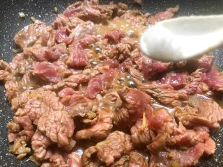 孜然牛肉,放入1g盐，翻炒2分钟，盖上盖子把锅里的汤汁焖干