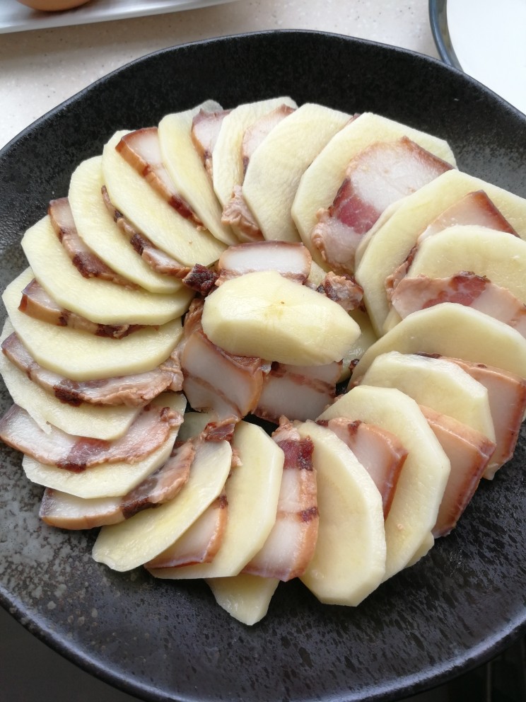 腊肉蒸土豆,一片土豆，一片腊肉，这样的摆成圆形，多余的放中间。