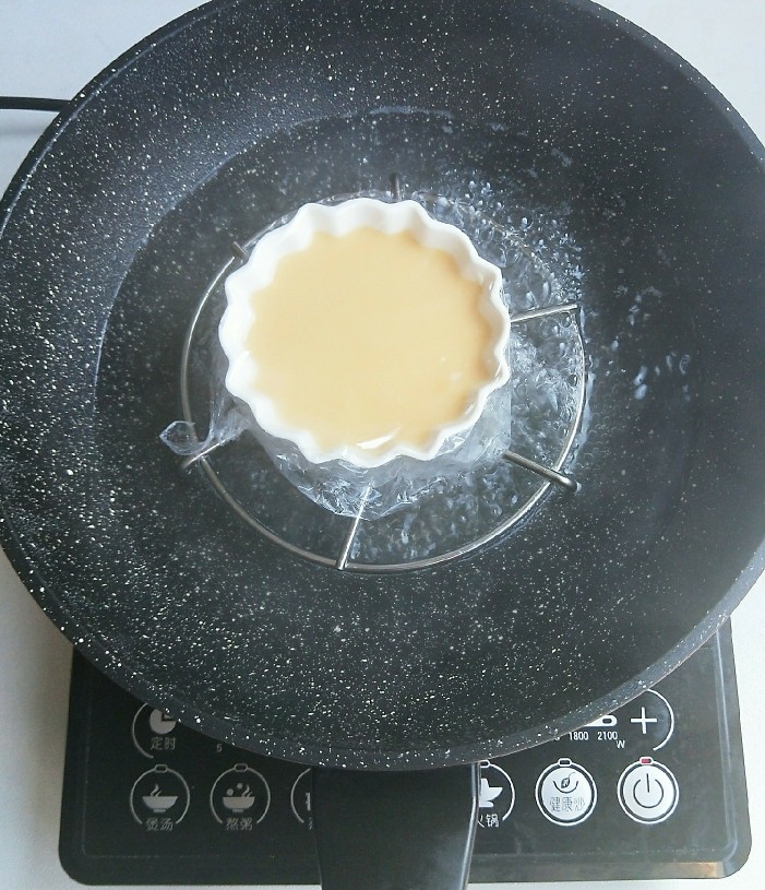 奶粉蛋黄布丁,锅里水烧开，鸡蛋液放入锅中。