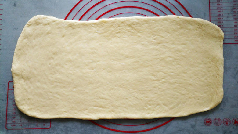 椰蓉手撕面包,将面团排气，平均分成两份，各自擀成长40厘米宽20厘米的面片
