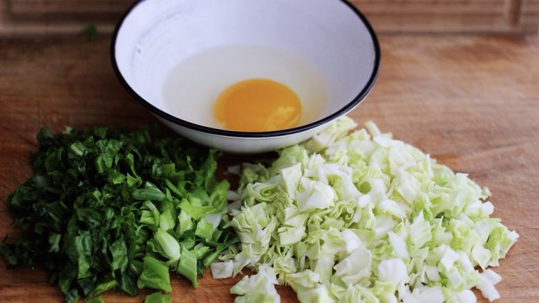 培根鸭蛋杂蔬炒饭,把一个鸭蛋打散在碗里，用筷子搅拌均匀，把莴苣叶和包菜用刀切成小块状备用；