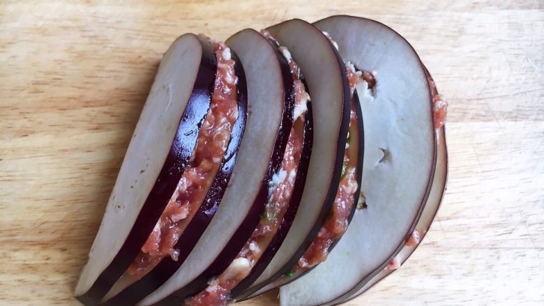 香炸茄子盒,将调好的肉靡夹在茄子片里，刮去周边多余的肉靡。