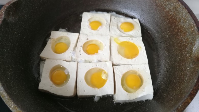 糖醋鹌鹑蛋豆腐,然后再把鹌鹑蛋打碎，填入豆腐的圆孔中，开中小火煎制。