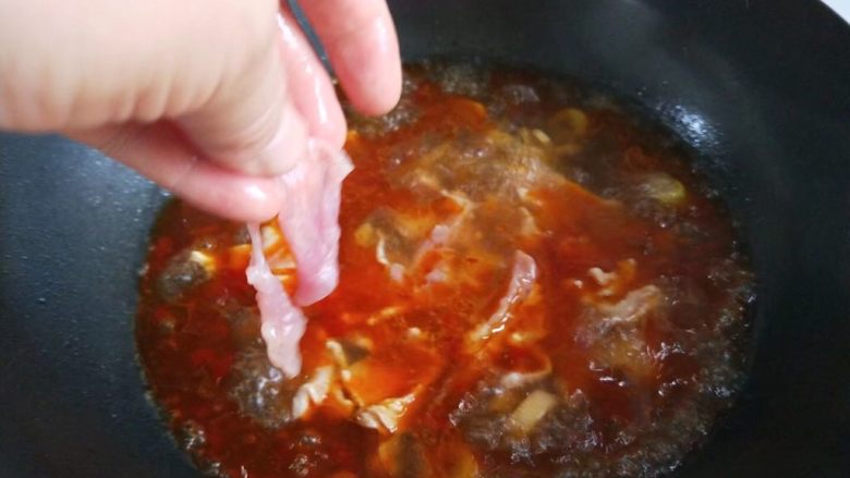 家常麻辣水煮肉片,一片片放入锅中。