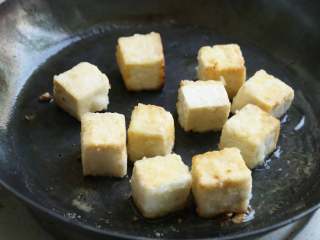 菠萝咕噜豆腐,锅内倒油加热，放入老豆腐块，煎至表皮呈金黄色后盛出沥油。