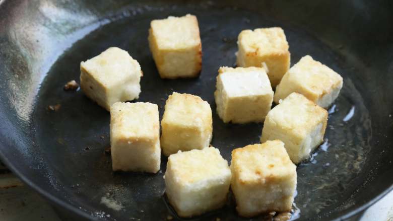 菠萝咕噜豆腐,锅内倒油加热，放入老豆腐块，煎至表皮呈金黄色后盛出沥油。