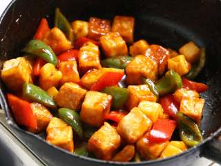 菠萝咕噜豆腐,将煎好的老豆腐回锅翻炒均匀，使其均匀裹上调味汁。