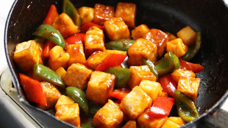 菠萝咕噜豆腐,将煎好的老豆腐回锅翻炒均匀，使其均匀裹上调味汁。