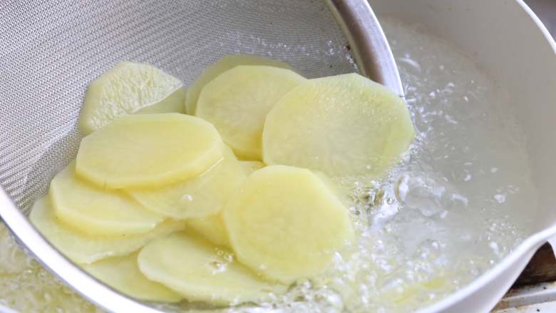 酸辣土豆片,煮开一锅清水，水沸加入土豆片焯水，直至土豆片呈半透明状，断生捞出。