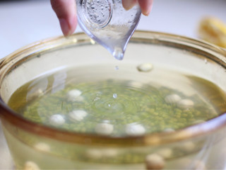 绿豆百合莲子羹,绿豆莲子放入锅中，加1升的纯净水，加一勺柠檬汁。用纯净水煮绿豆和水中加柠檬汁都是为了防止绿豆汤被氧化，保证汤色清绿。柠檬汁的量以不影响绿豆汤的口感为准。