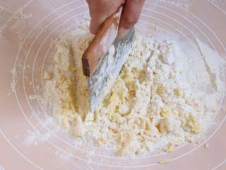 酥皮泡芙,首先制作酥皮部分。糖粉面粉混合过筛至操作台上，将冷藏黄油放在粉上，用刀切碎至无大颗粒。