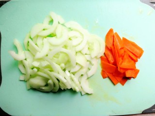 时蔬炒意粉,首先把吊瓜削皮，对半切开，挖出里面的籽，切片，红萝卜削皮切片