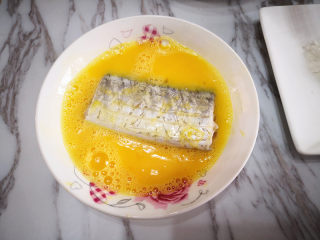 香煎带鱼,将腌好的带鱼先放在蛋液中，将其均匀地裹上蛋液，