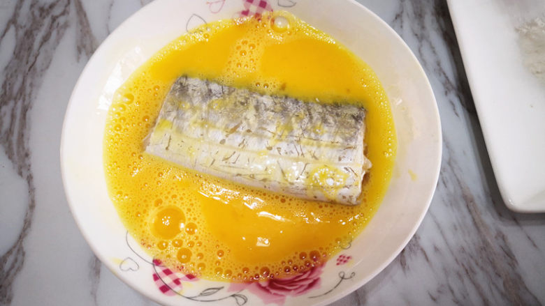 香煎带鱼,将腌好的带鱼先放在蛋液中，将其均匀地裹上蛋液，