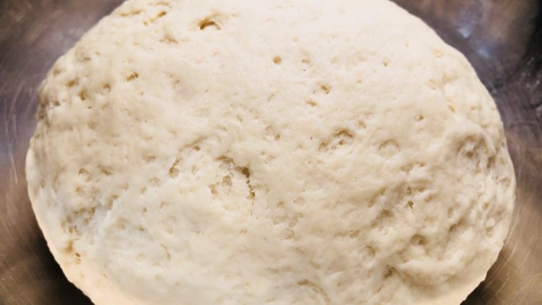 奶香松软大馒头,逐渐的加入发酵粉的温牛奶并搅拌面粉至絮状，和好的面揉光