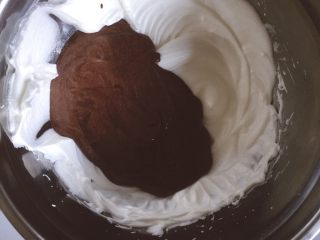 巧克力戚风,将翻拌均匀后的巧克力面粉倒入蛋白霜中，翻拌均匀。