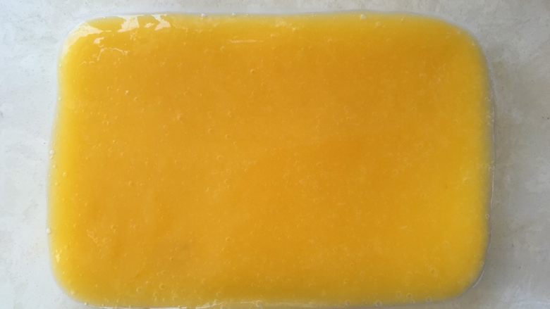 芒果千层糕,之后用刮棒刮平正，入冰箱继续冷藏10几分钟，至芒果层凝固不流动即可