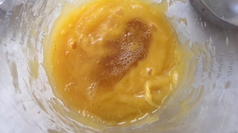 芒果千层糕,将融化的吉利丁液加入到芒果泥中搅拌均匀