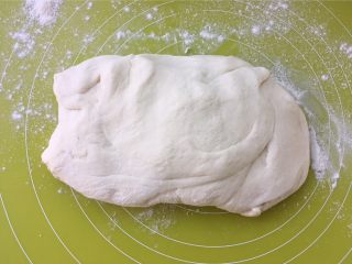 独角兽奶黄包,将发酵好的面团取出，撒点干粉，按压排气，之后揉均匀，盖保鲜膜松弛