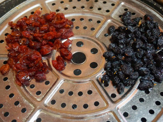 蔓越莓糯米糕,蔓越莓干和黑加仑用清水清洗一遍后，放入蒸锅中大火蒸8分钟变软即可

