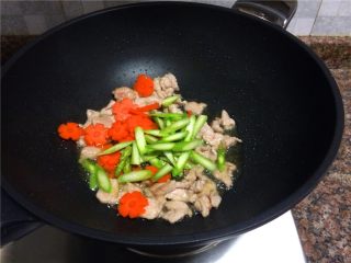 双耳菜花炒肉片,放入胡萝卜片和芦笋翻炒20秒。