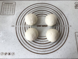梭形砂糖面包,排气后将面团均分4份。滚圆后盖上保鲜膜松弛20分钟。