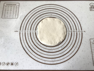 梭形砂糖面包,取一面团，压扁成圆形。